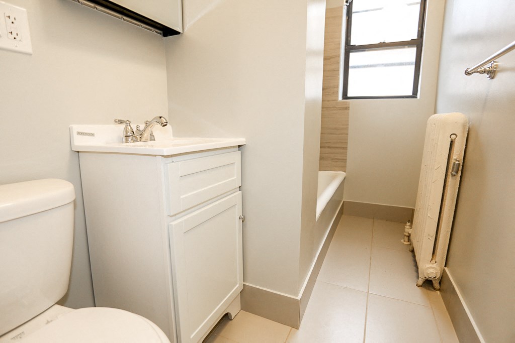 a bathroom with a toilet and a sink and a window