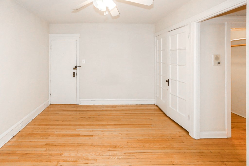an empty room with a wood floor and white doors