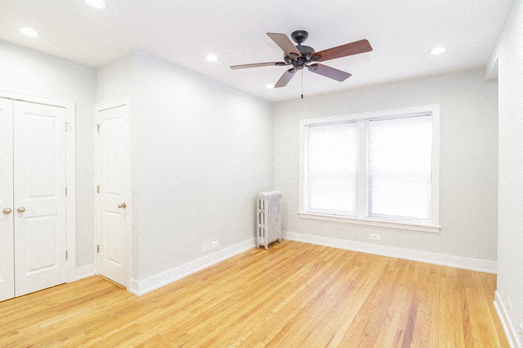 an empty room with a ceiling fan and a window