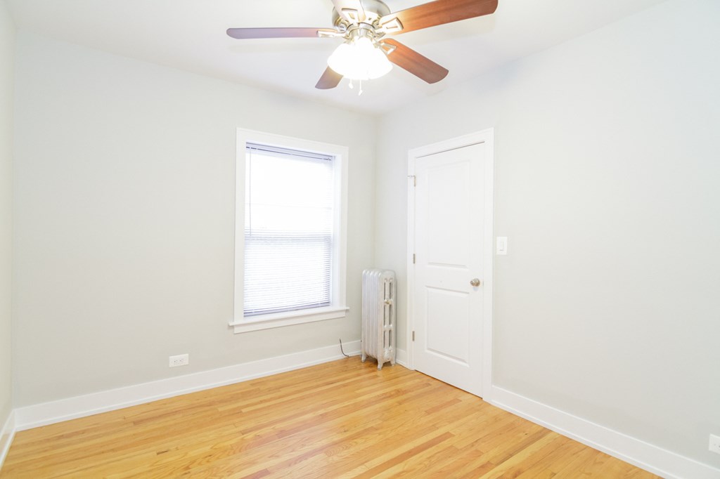 an empty room with a ceiling fan and a window