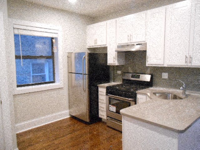 a kitchen with a stove refrigerator and a window