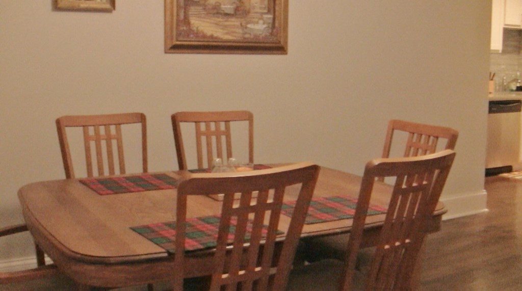 a dining room with a wooden table and chairs