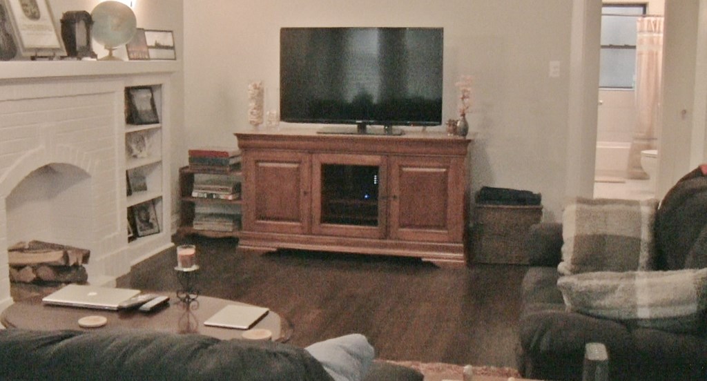 a living room with a tv on top of a wooden entertainment center