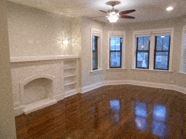 a living room with a fireplace and a wooden floor