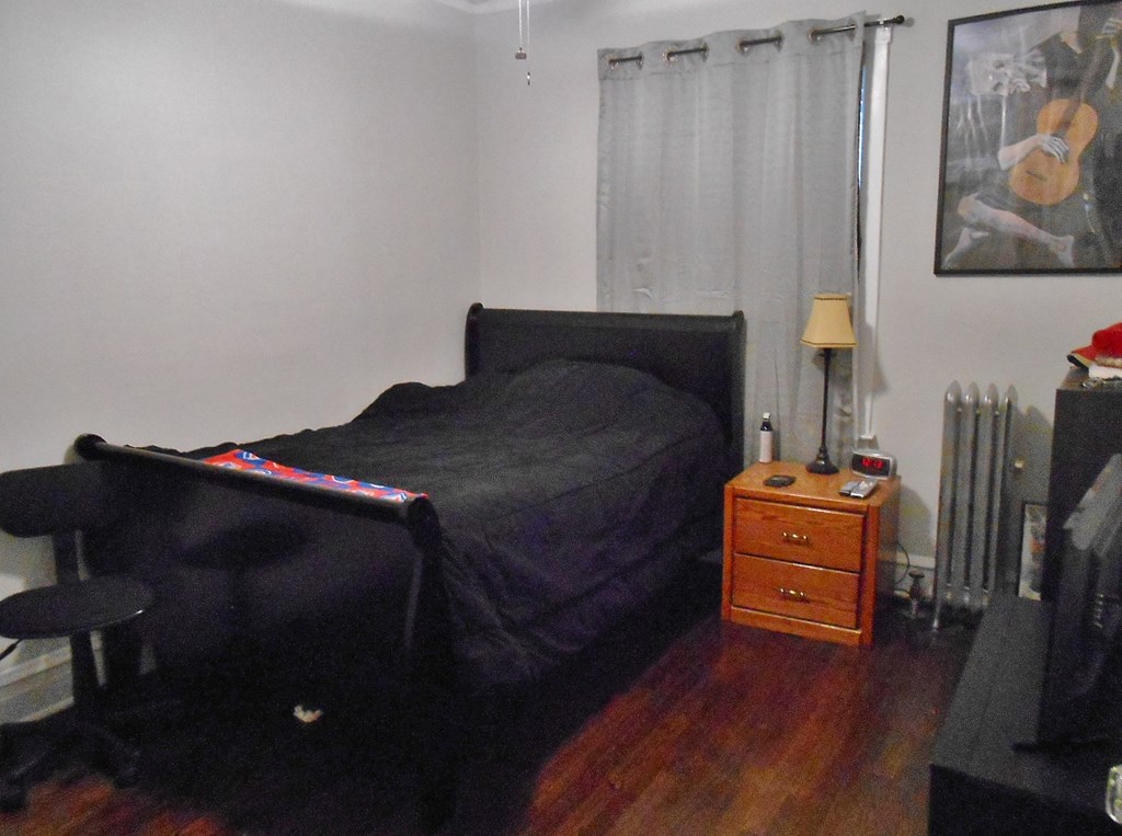 a bedroom with a bed and a dresser in it