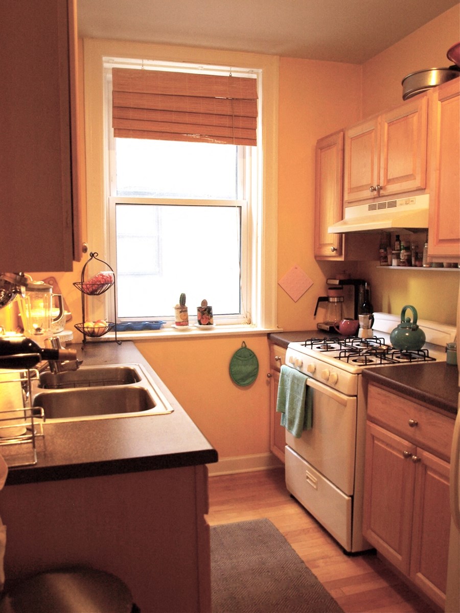 a kitchen with a stove and a sink and a window