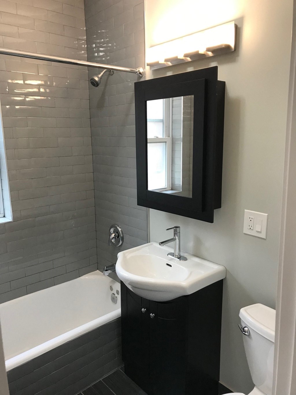a small bathroom with a sink and a mirror and a tub