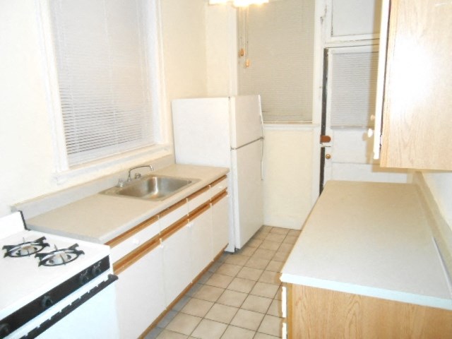 an empty kitchen with a sink and a refrigerator