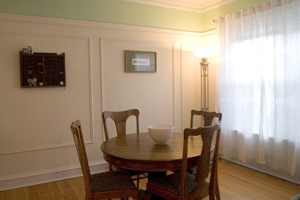 a dining room with a table and chairs and a lamp