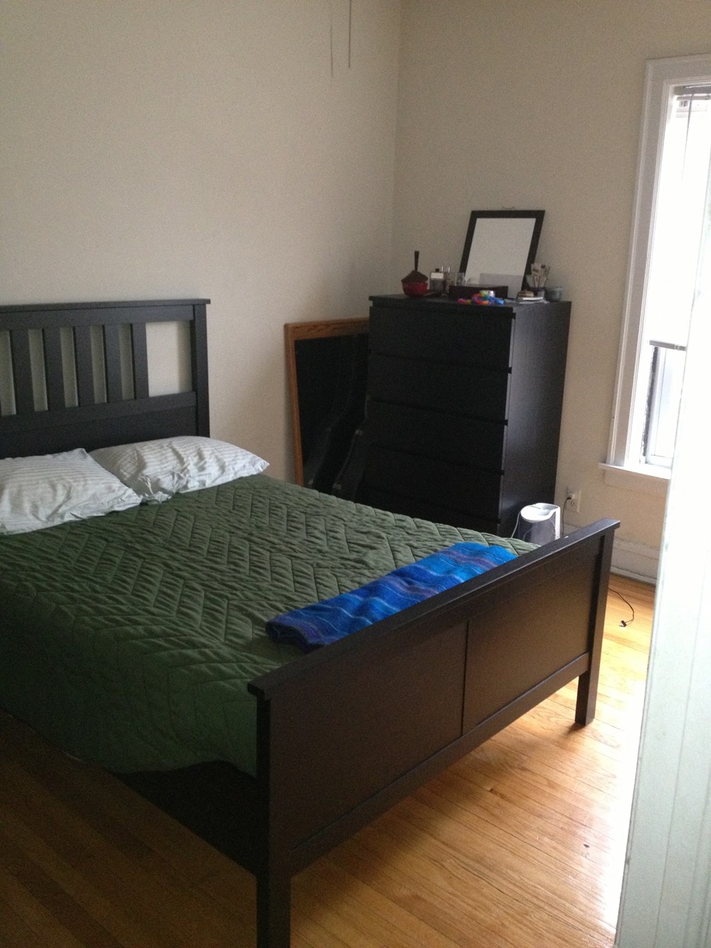 a bedroom with a bed and a dresser in it
