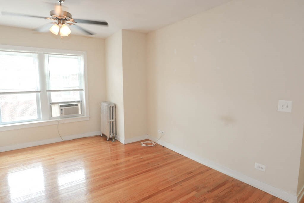 an empty room with a ceiling fan and a window