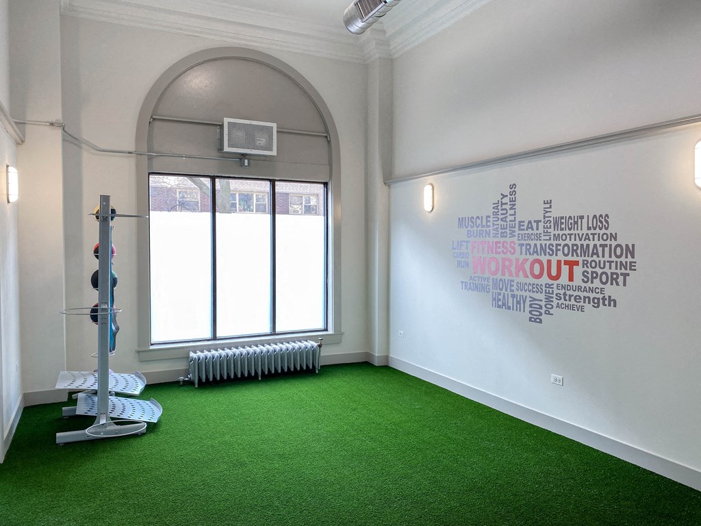 a yoga room with green carpet and a window