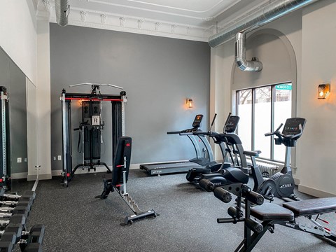 a gym with cardio machines and weights on the floor