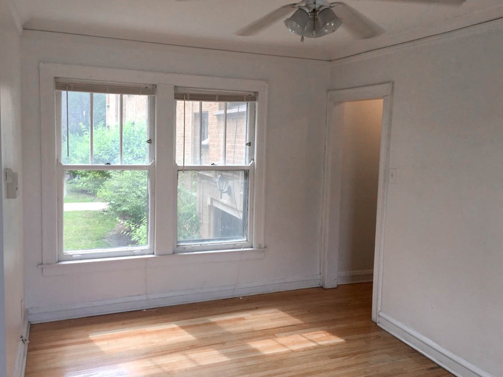 a living room with two windows and a wooden floor