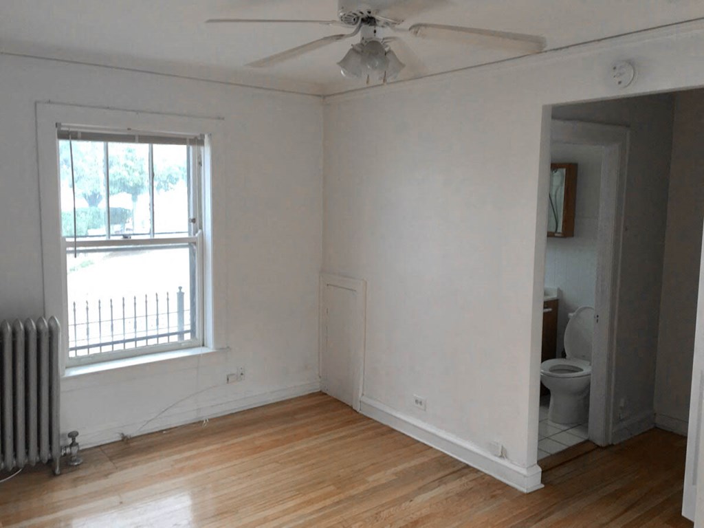 an empty room with a ceiling fan and a window