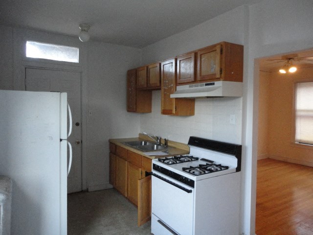 a kitchen with a stove and a sink and a refrigerator