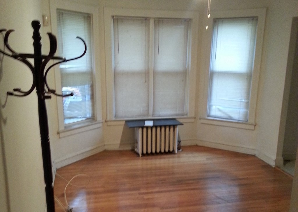 an empty living room with windows and a wood floor