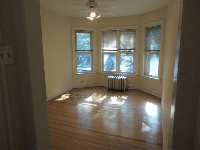an empty living room with a wood floor and windows