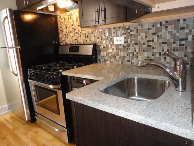 a kitchen with a sink and a stove and a refrigerator