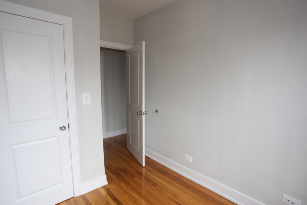an empty room with wooden floors and white doors
