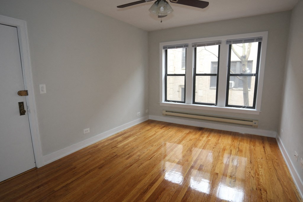an empty living room with wood floors and a window
