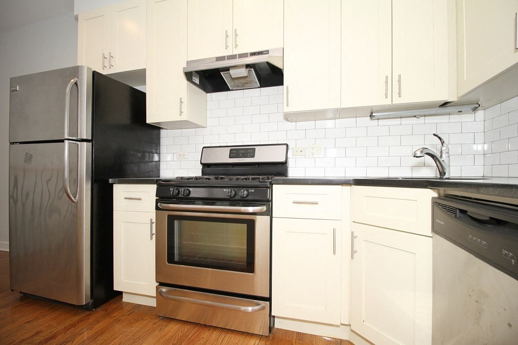 a white kitchen with stainless steel appliances and white cabinets