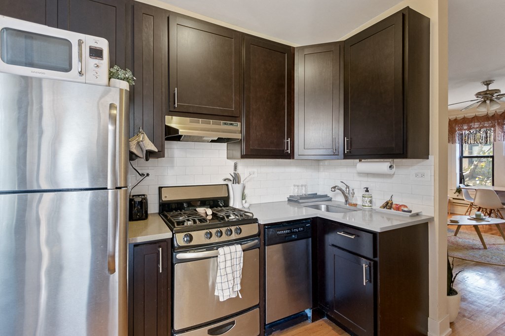 a kitchen with stainless steel appliances and dark wood cabinets