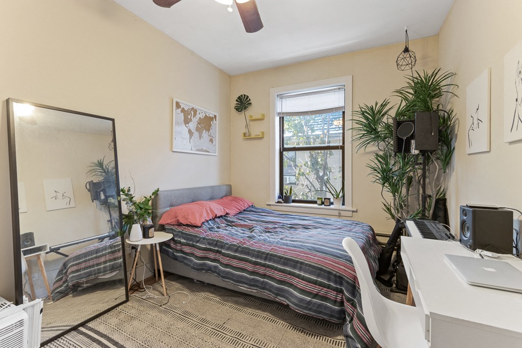 a bedroom with a bed and a desk and a window