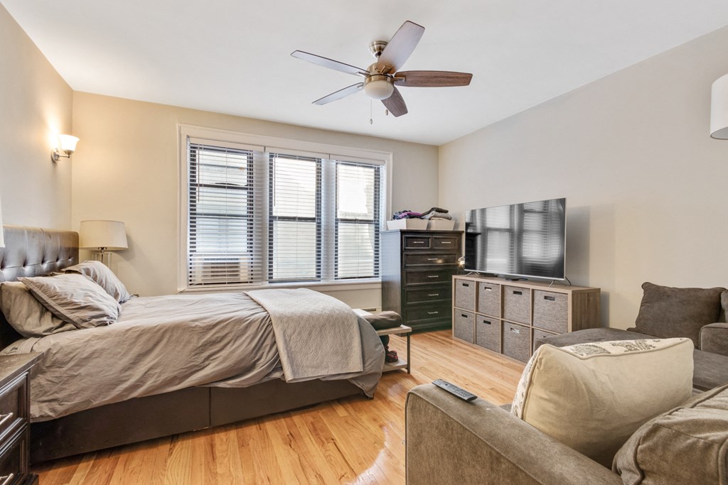 a bedroom with a bed and a couch and a ceiling fan