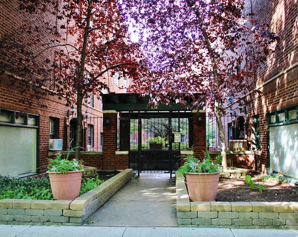 the entrance to a building with trees and plants