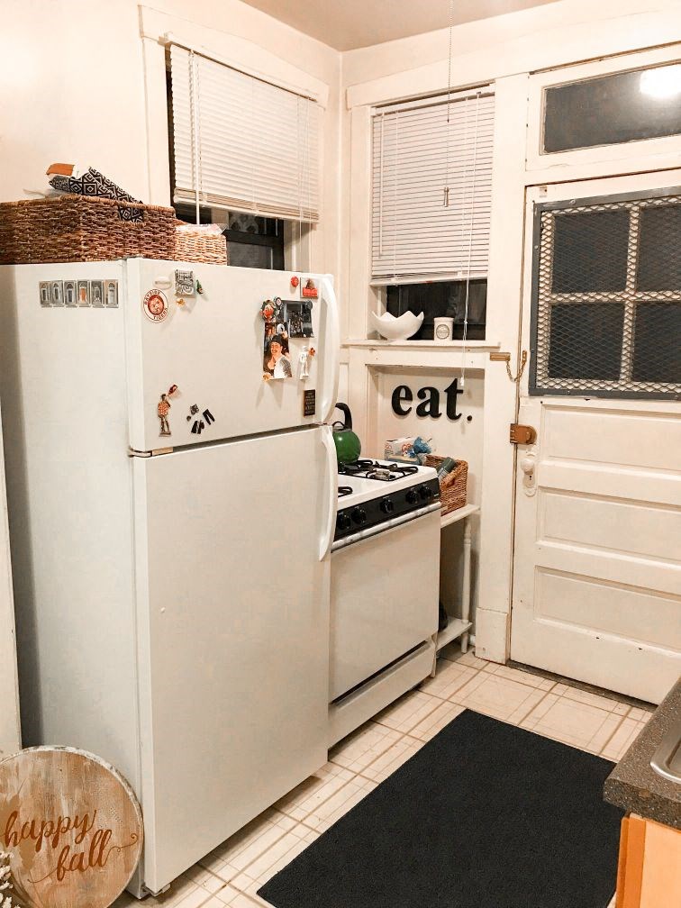 a kitchen with a refrigerator and a stove and a door