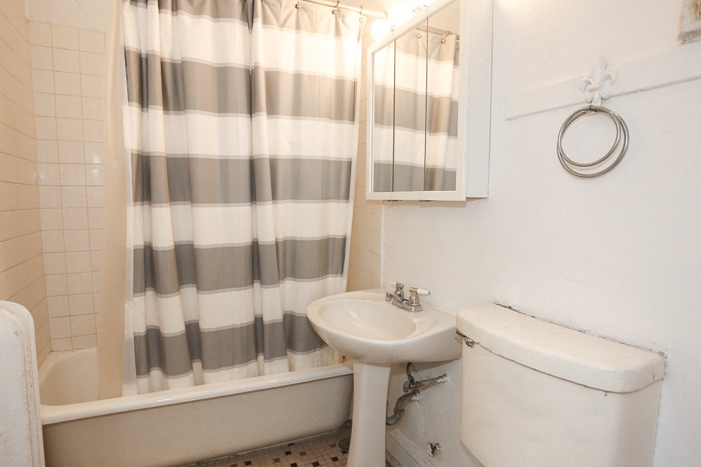 a bathroom with a shower curtain and a sink and a toilet