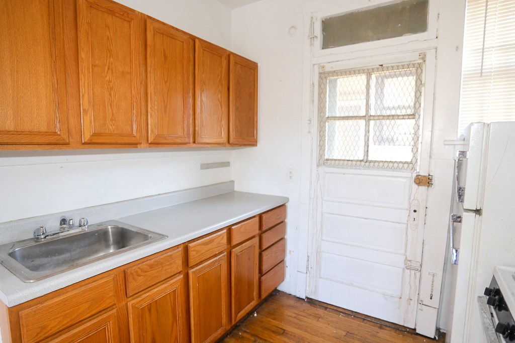 an empty kitchen with a sink and wooden cabinets