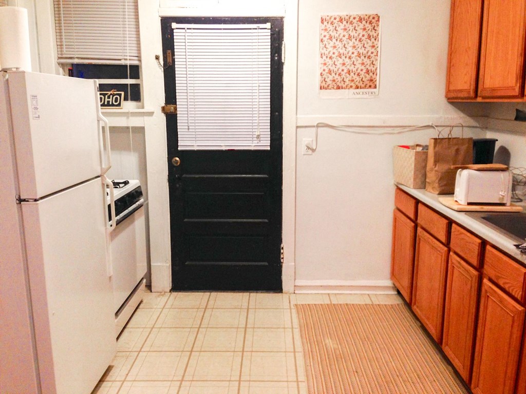 a kitchen with a black door and a refrigerator