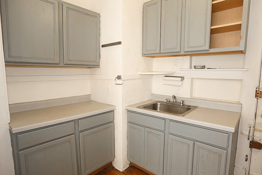 an empty kitchen with blue cabinets and a sink