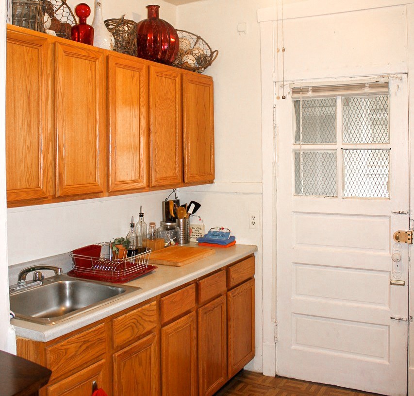 a kitchen with wooden cabinets and a sink and a door
