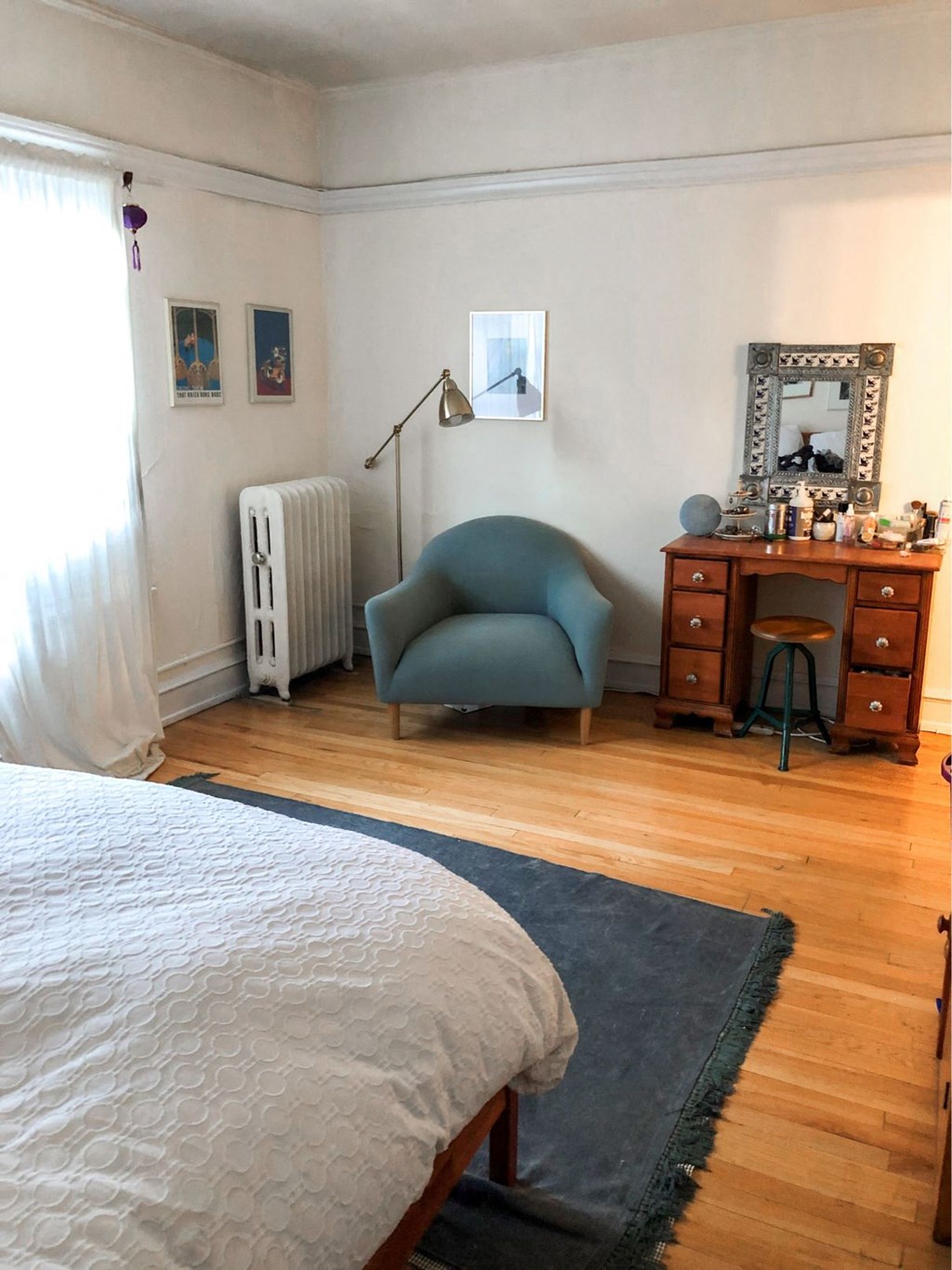 a bedroom with a bed and a chair and a dresser