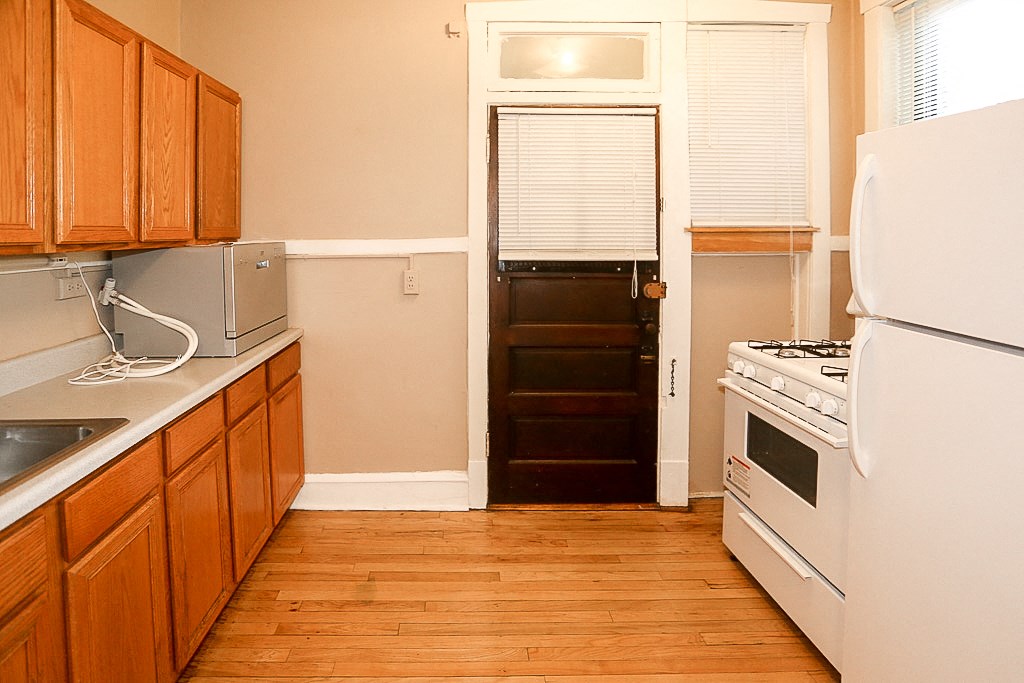 a kitchen with a refrigerator and a stove and a door