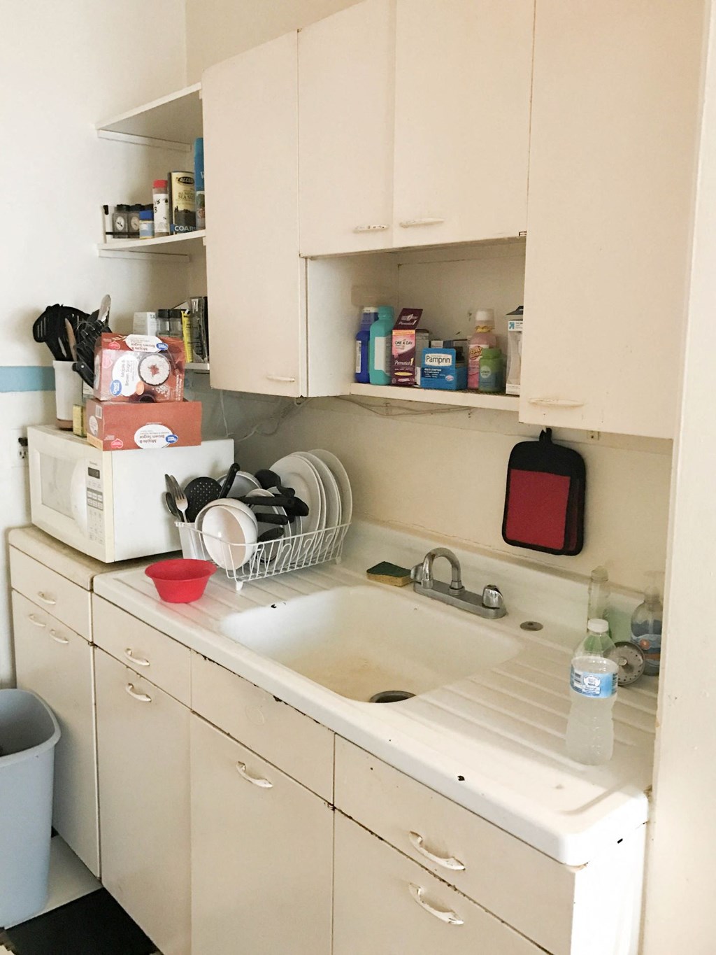 a small kitchen with white cabinets and a sink