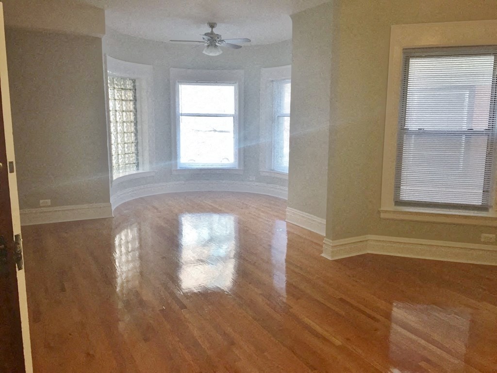 a living room with a hard wood floor and a ceiling fan