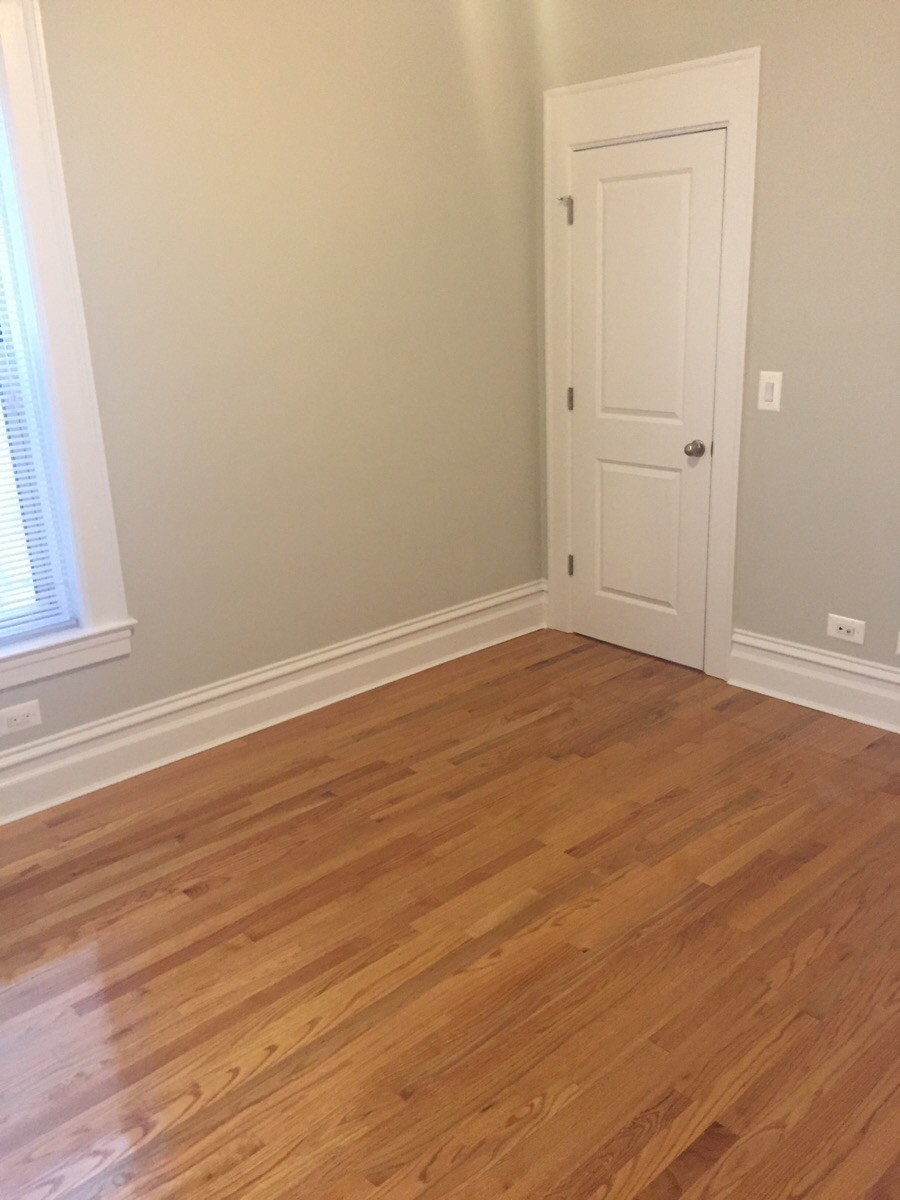 an empty room with wooden floors and a door