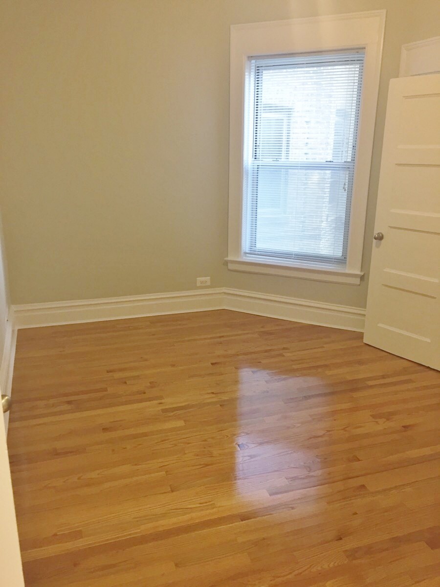 an empty room with wooden floors and a window