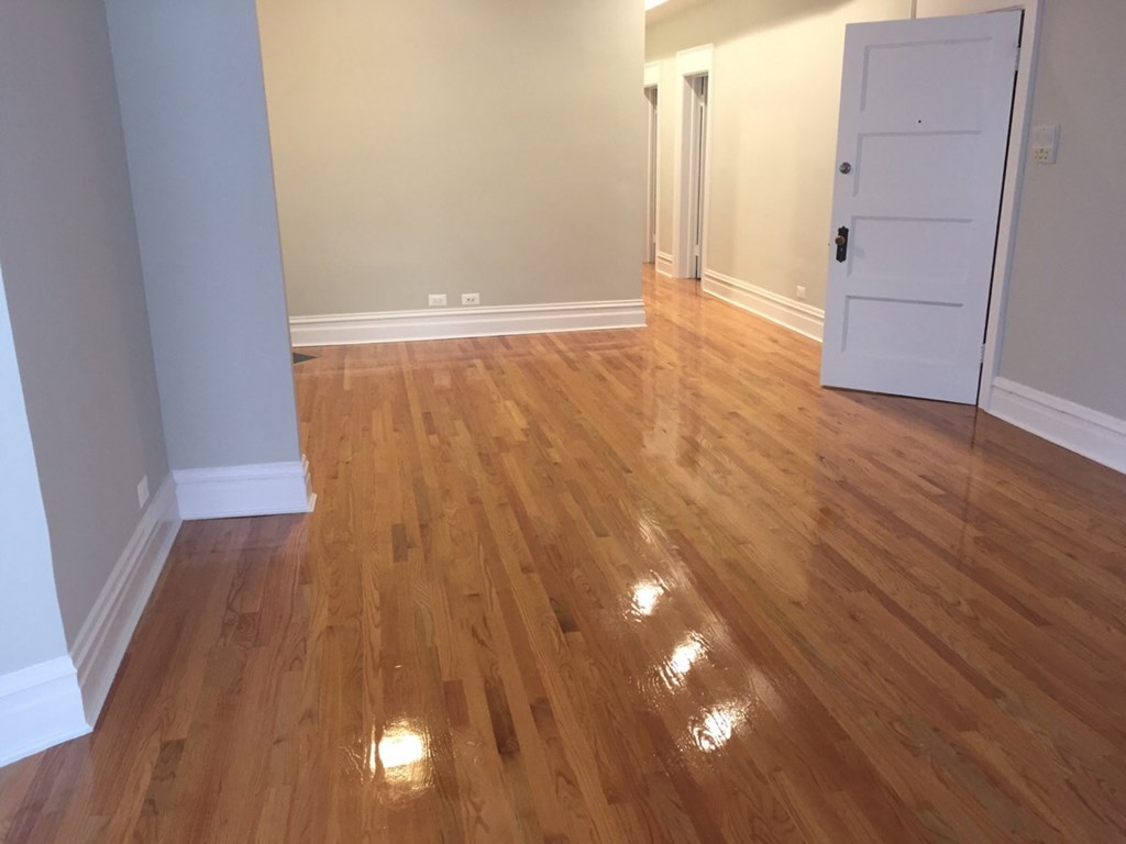 a living room with a hard wood floor and a white door