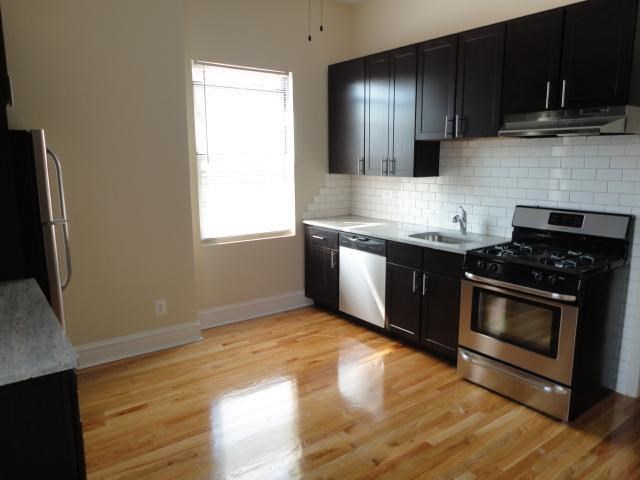 a kitchen with black cabinets and stainless steel appliances