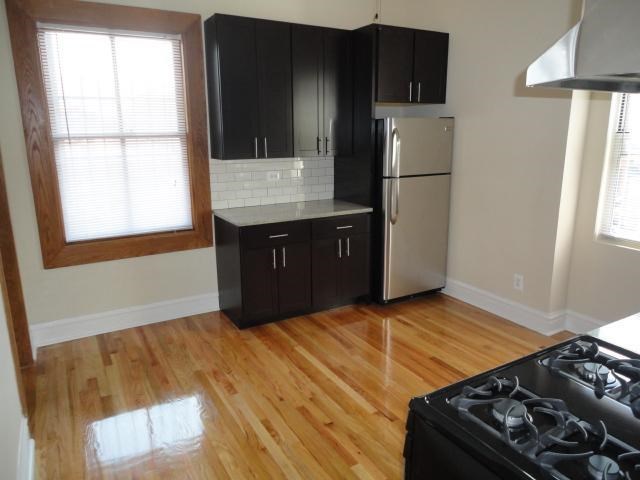 an empty kitchen with a stove and a refrigerator