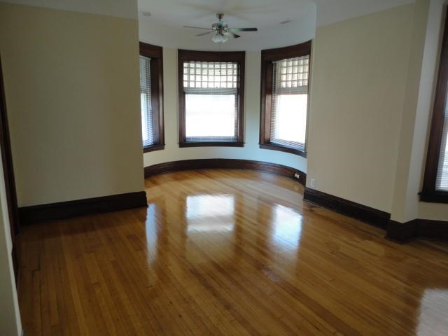 an empty living room with a hard wood floor and windows