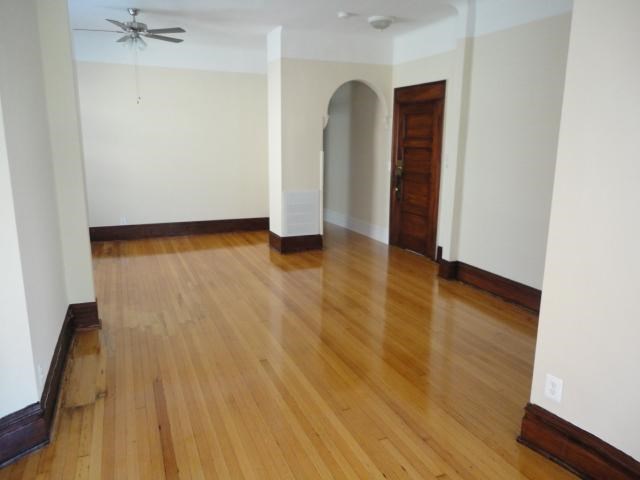 an empty living room with a wooden floor