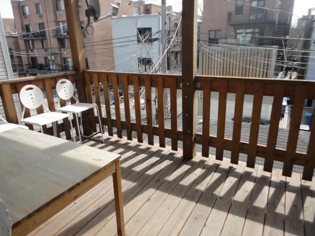 a balcony with a table and chairs on it