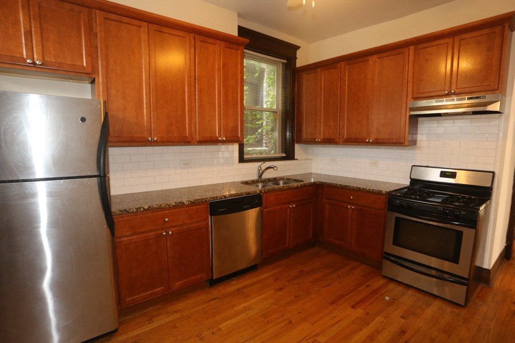 a kitchen with wooden cabinets and stainless steel appliances