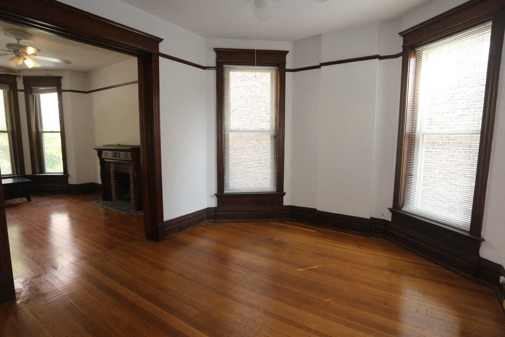 an empty living room with wood floors and windows